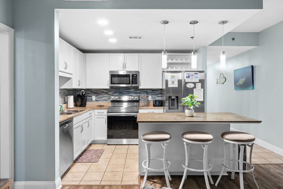 Modern kitchen layout featuring pendant lighting, stainless appliances, and plenty of counter space.