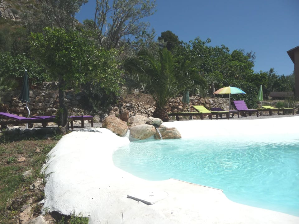 Natural lake-shaped pool in the middle of a Mediterranean garden with great view