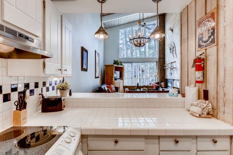 Kitchen and bar that opens to dining and living area.