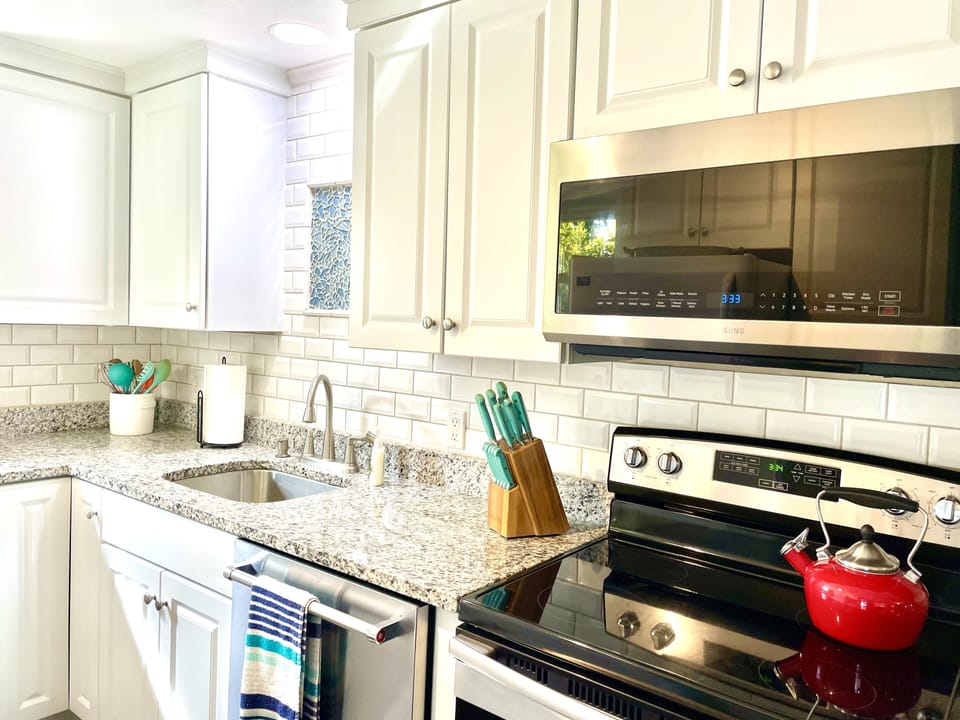 Newly renovated kitchen with granite counter tops and tiled backsplash.