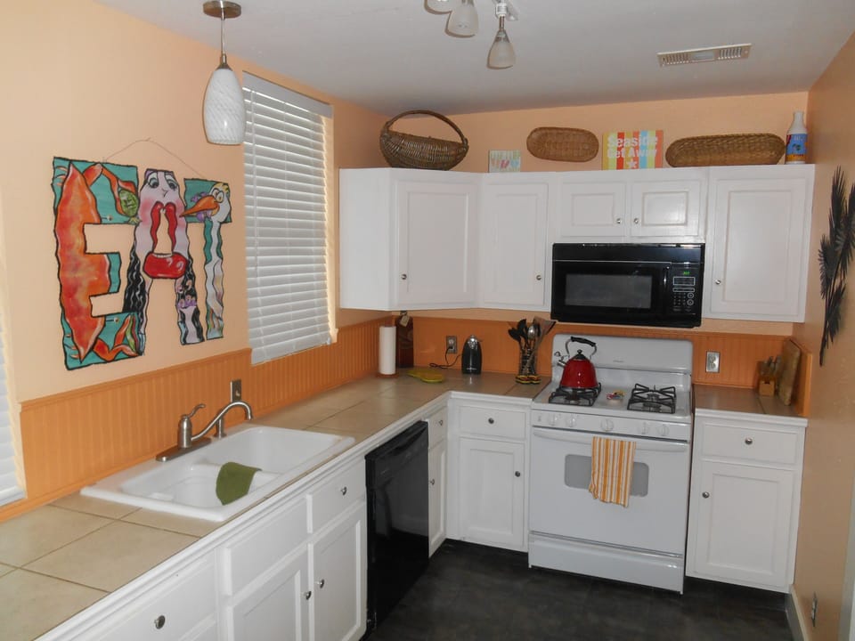 Large, colorful kitchen fully stocked with everything you need for entertaining.