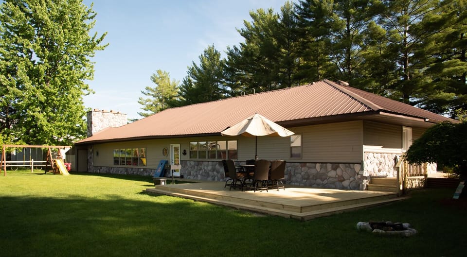 Spacious Back Yard with floating patio, grassy yard and swingset