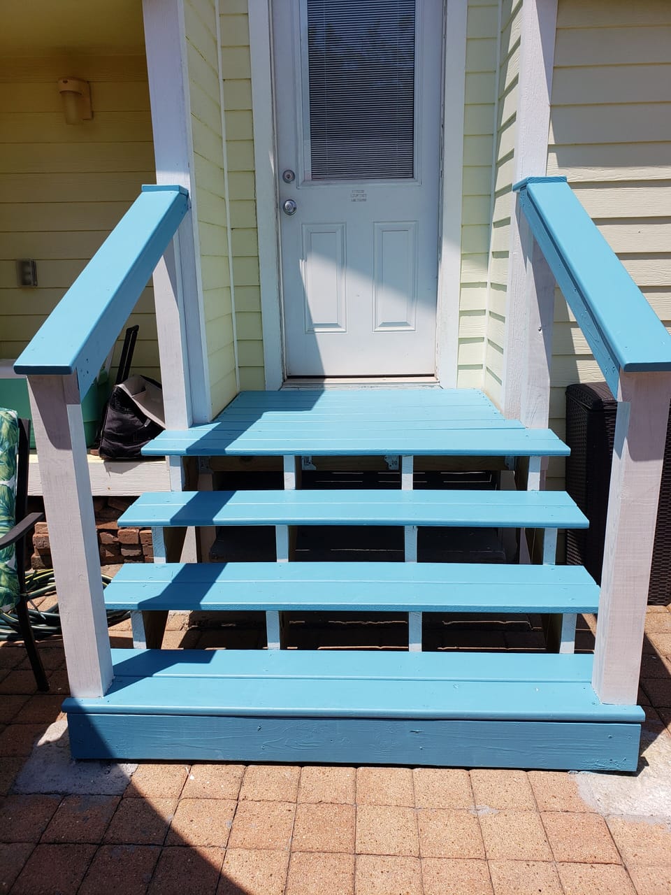 Deck and steps leading into the backyard with handrails for safety.