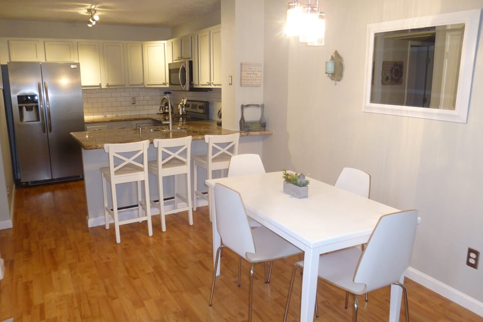 Dining room and kitchen with bar stools
