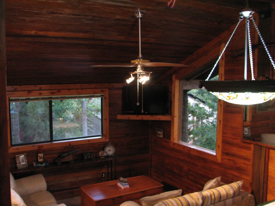 The living room has a high ceiling and lots of natural light. 