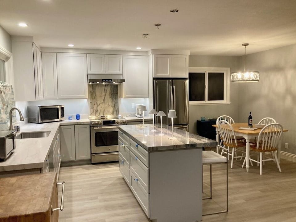 New quartzite island has plenty of space for kitchen prep and seating for three.