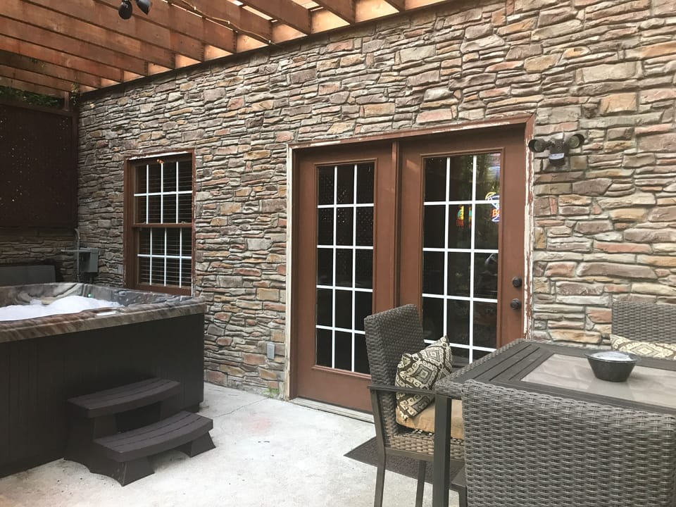 Lower level jacuzzi, patio table, privacy fence on one end.