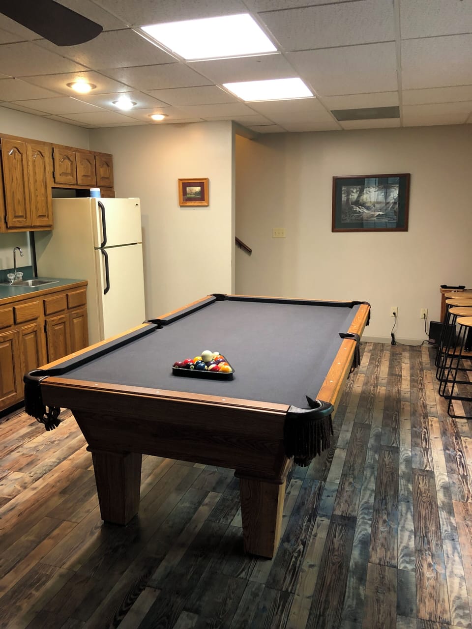 Basement with pool table and refrigerator/freezer