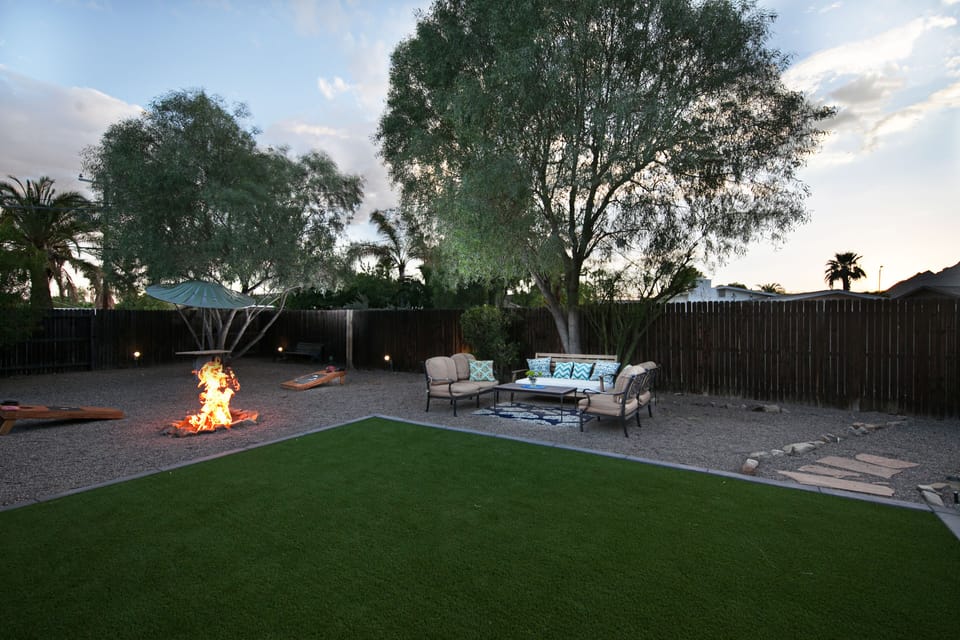 Backyard - firepit, patio seating, grass turf, picnic table w/ metal parasol