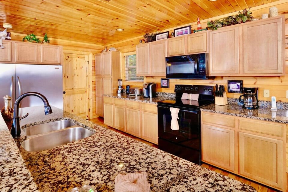 The fully-equipped kitchen has granite countertops, massive fridge & big island
