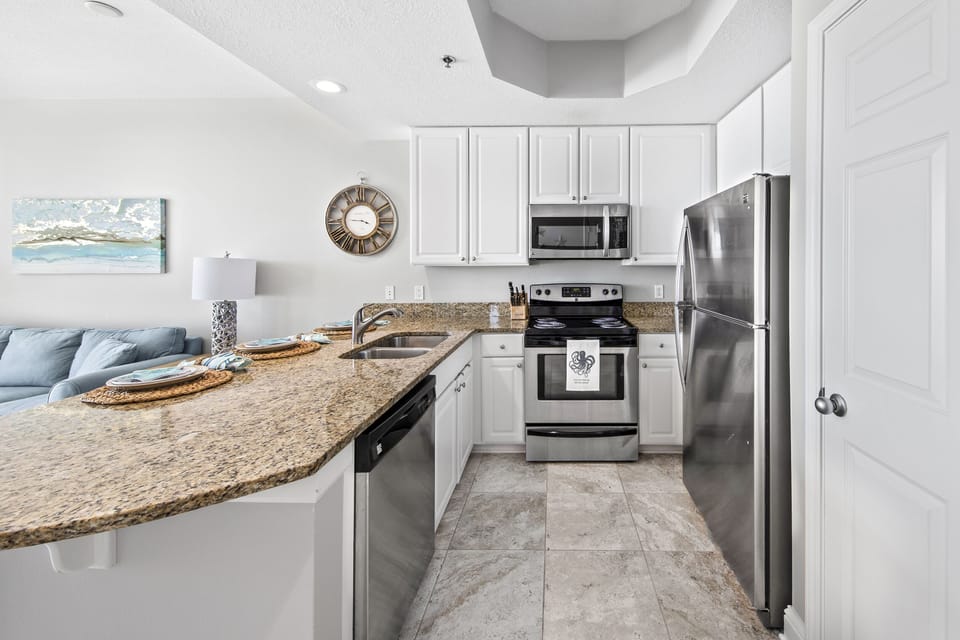 Fully stocked kitchen with stainless steel appliances.