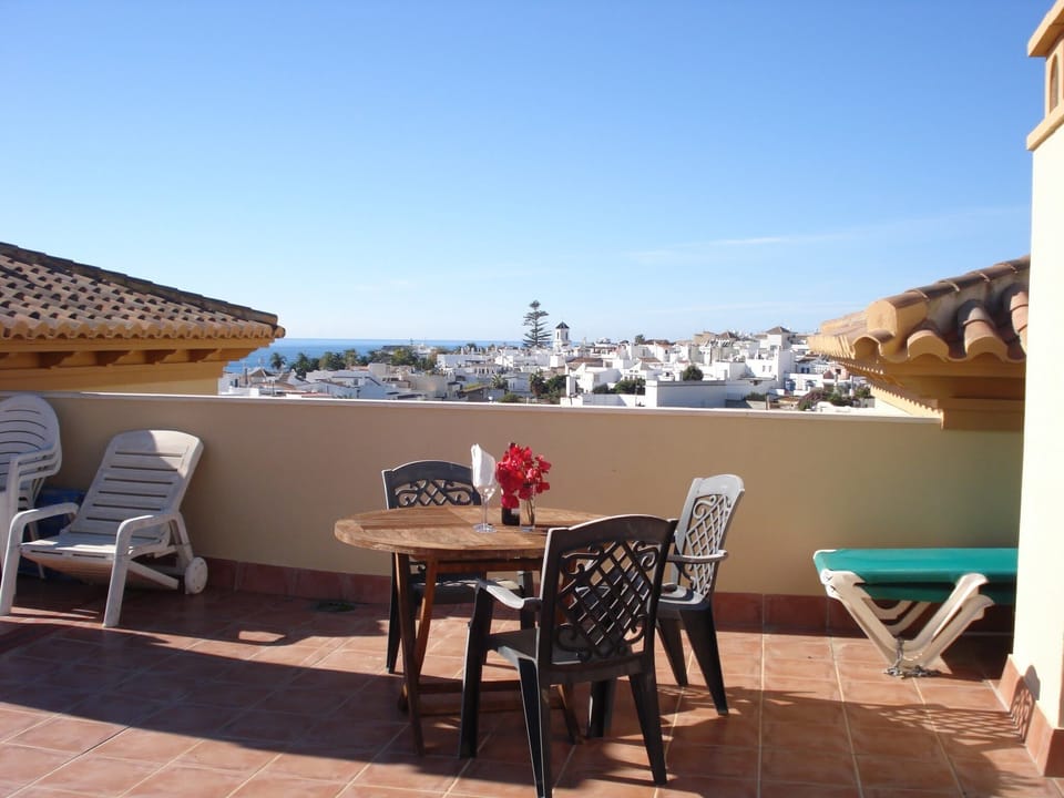 Sunny roof terrace with balcon church in background