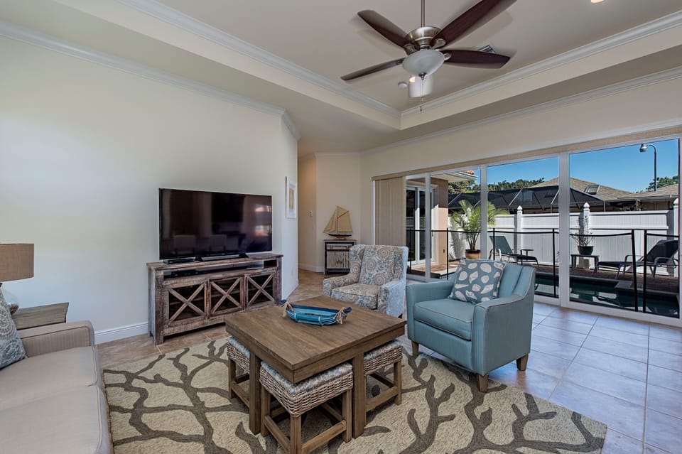 Main Living area 60" HDTV full wall of sliders leading to pool Seats 10