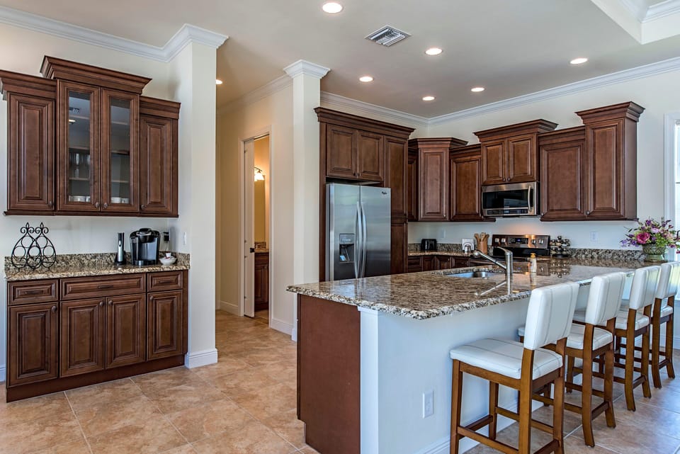 Huge granite kitchen breakfast bar w/ seating view of pool. Very well equipped