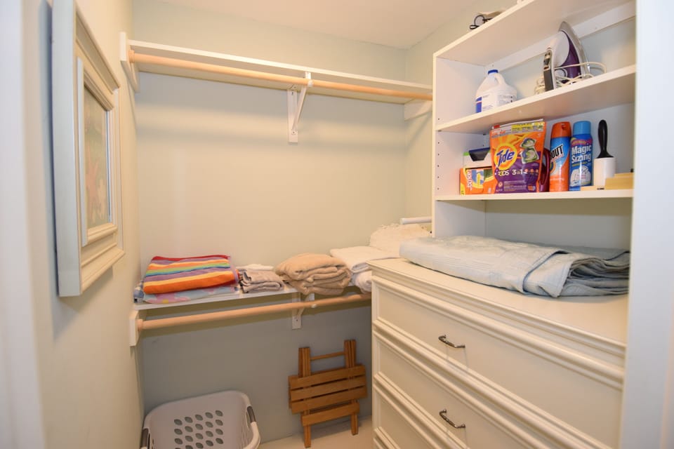 Walk-in closet with white vanity to store clothes in. Laundry supplies included!