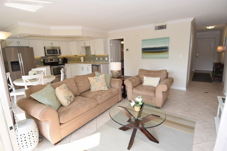 The costal living area with Pottery Barn furniture and glass table. 