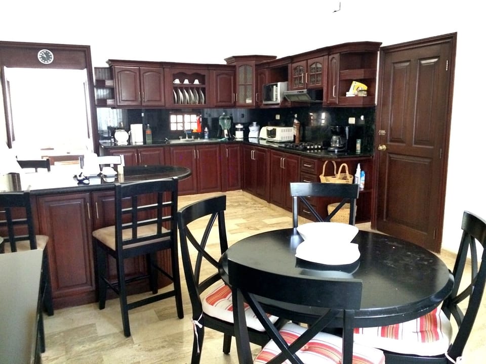 The main kitchen includes breakfast table for 4 and kitchen bar seating for 4.