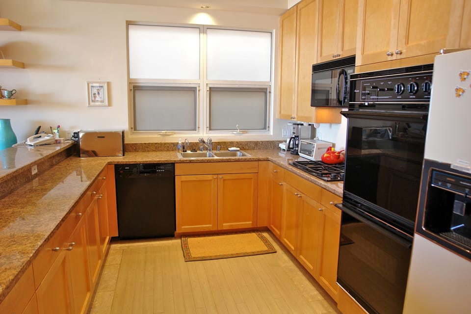 Kitchen with breakfast bar is fully-stocked & has top-of-the line appliances
