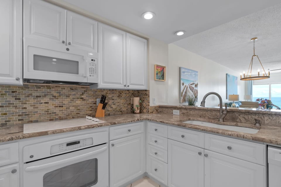 Beautiful sea glass back splash, and exquisite granite counter-tops from Brazil.