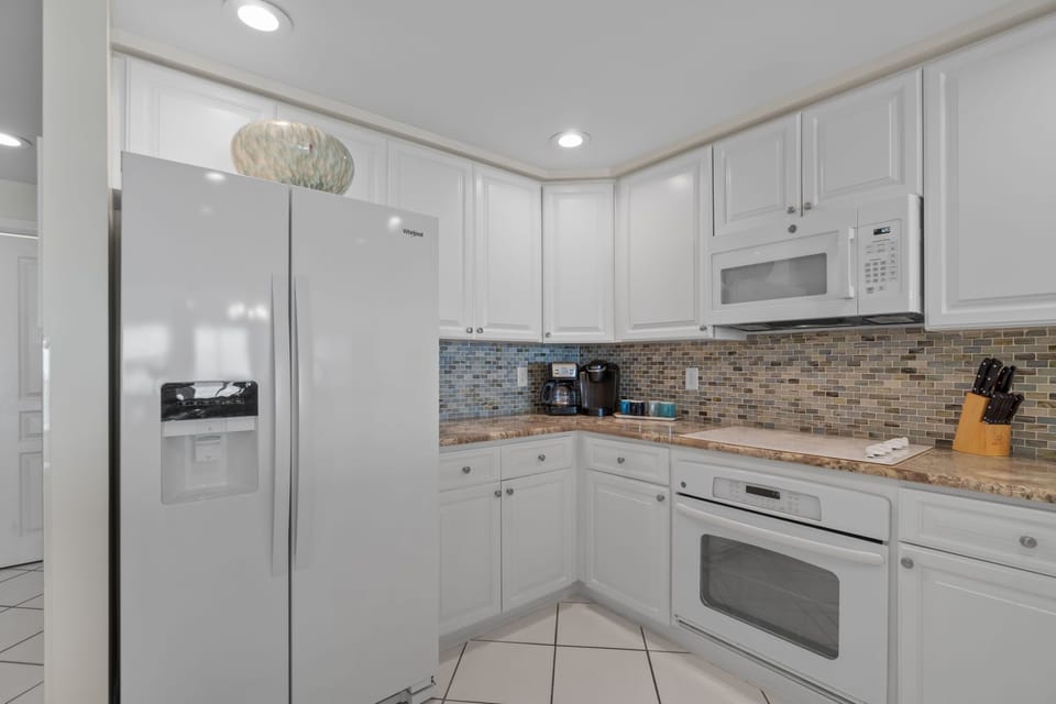 Beautiful sea glass back splash, and exquiste granite counter-tops from Brazil.