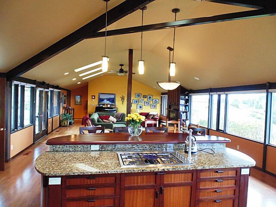 From this custom kitchen island, views of the water, yard, and even the TV. 