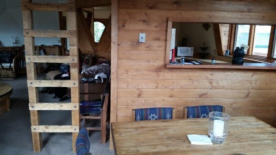 Dining space, serving window to kitchen & ladder to loft. 
