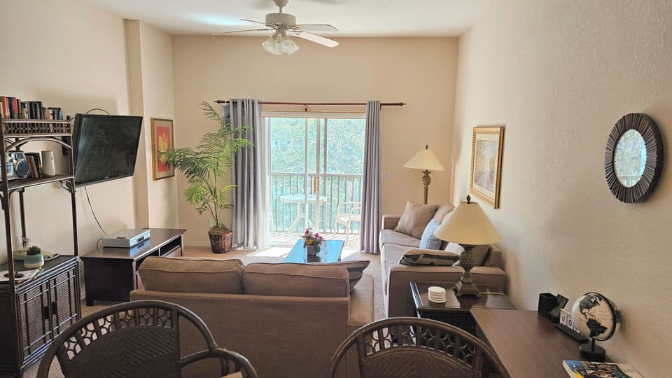 Living room w/ 50'flat screen TV, Queen sofa bed, desk & screened balcony
