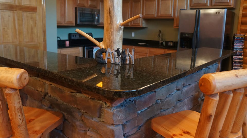 Luxury open kitchen with granite counter tops and 4 log bar stools. 