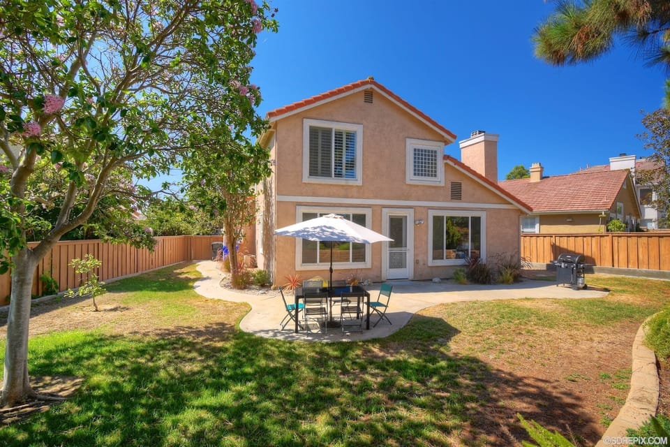large fenced backyard with table and seating for 8, propane BBQ