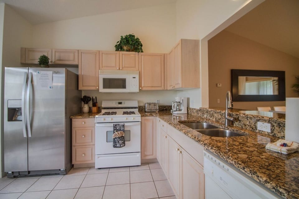 Tuscan Villa Kitchen with Stainless Steel Refrigerator and Granite Countertops