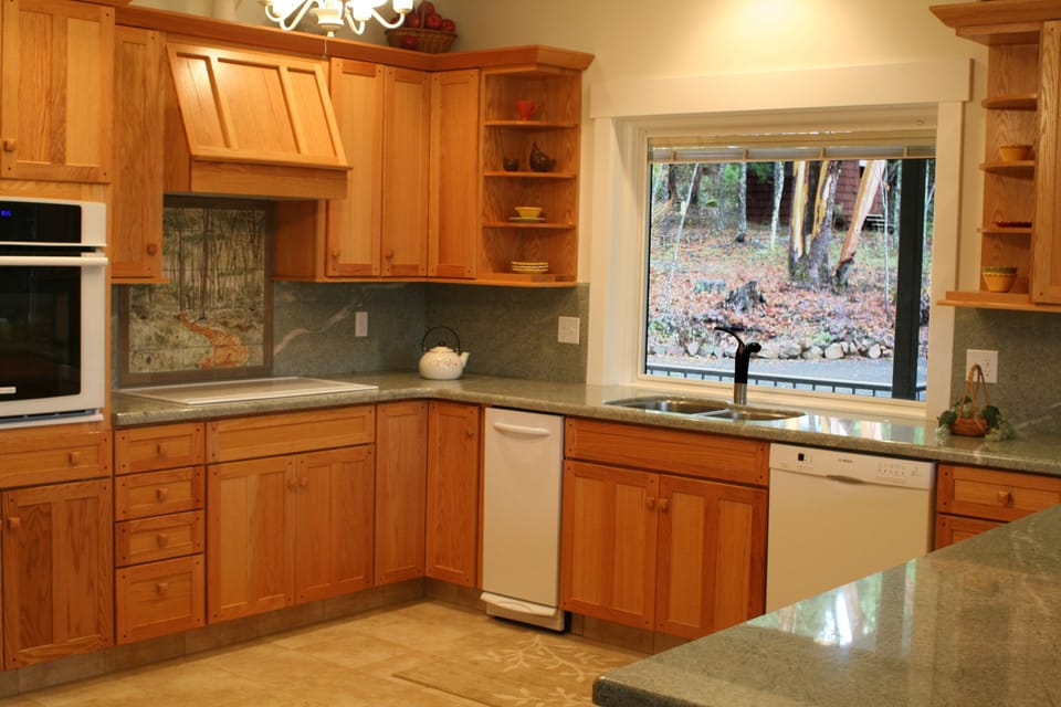 Large fully equipped kitchen w/ view of woodlands, small wellhouse in distance