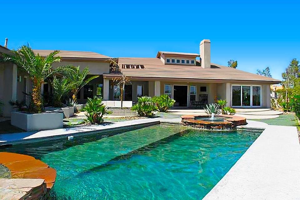 View of home from backyard pool and hot tub