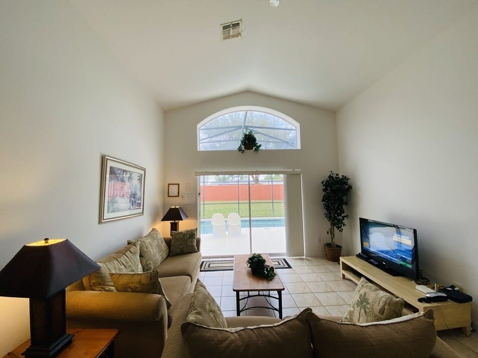 Bright and Airy Family Room with Double-Height Ceiling Overlooking Private Pool