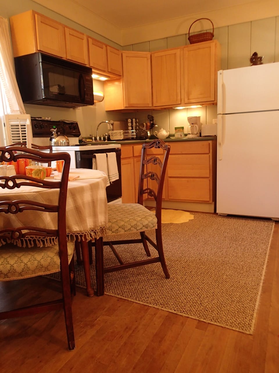 This is another view of the kitchen, which has a vented stove and microwave.