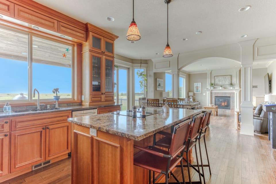 Large open space from the kitchen to the living room with a west wall of windows