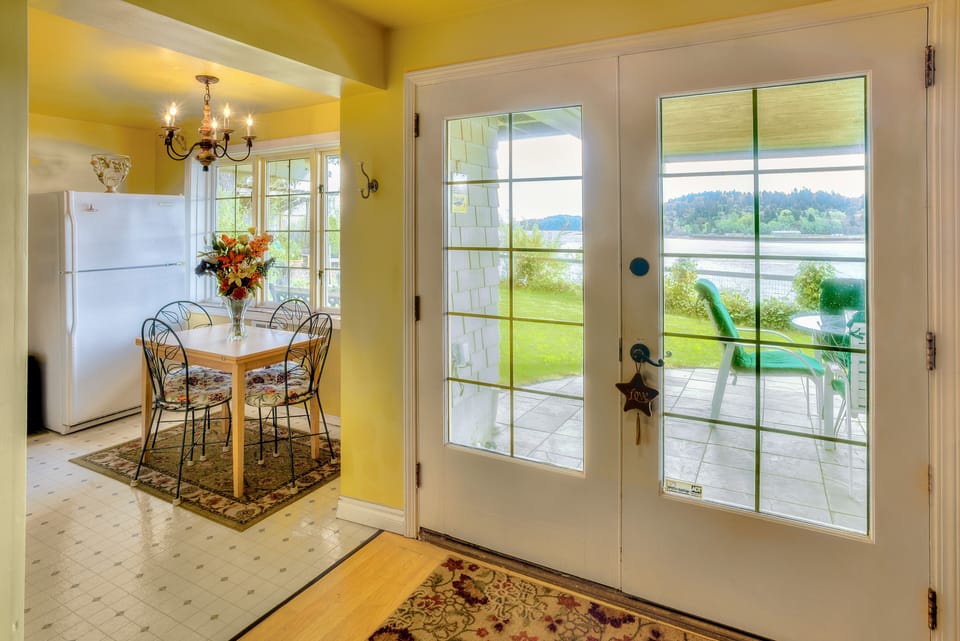 Entry door with patio seating outside & kitchen table and full fridge on left