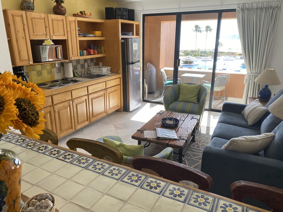 Counter area for eating, kitchen, living room, balcony, and view.