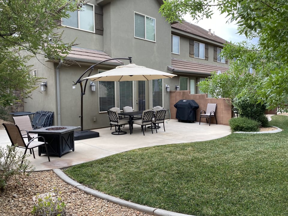 Spacious back yard and patio with fire pit, table/chairs, shade umbrella, BBQ