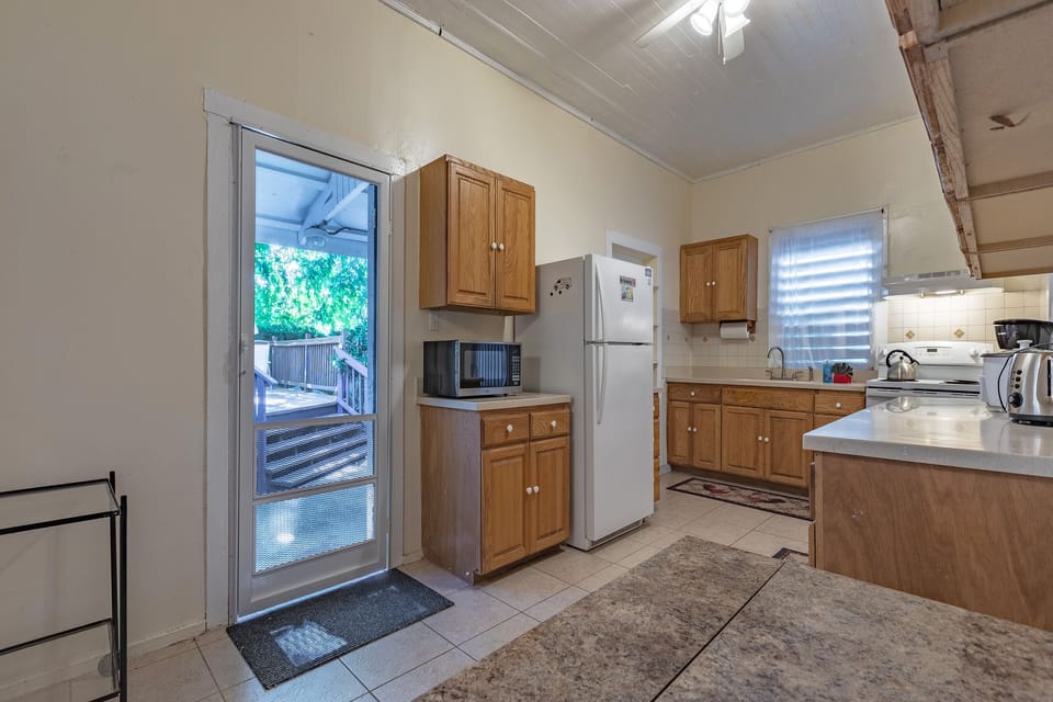Kitchen leads to outside fenced backyard.