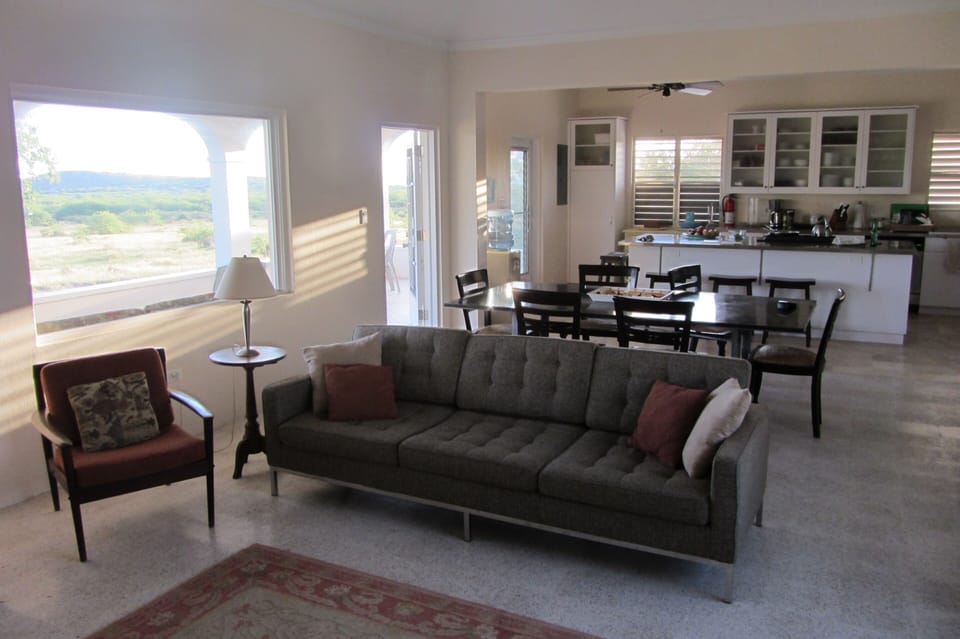 The living, dining, and kitchen areas open to the gallery-style front porch.