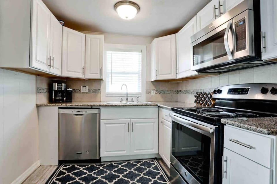 Efficient kitchenette is well stocked with new cookware and bakeware to make meal prep a snap