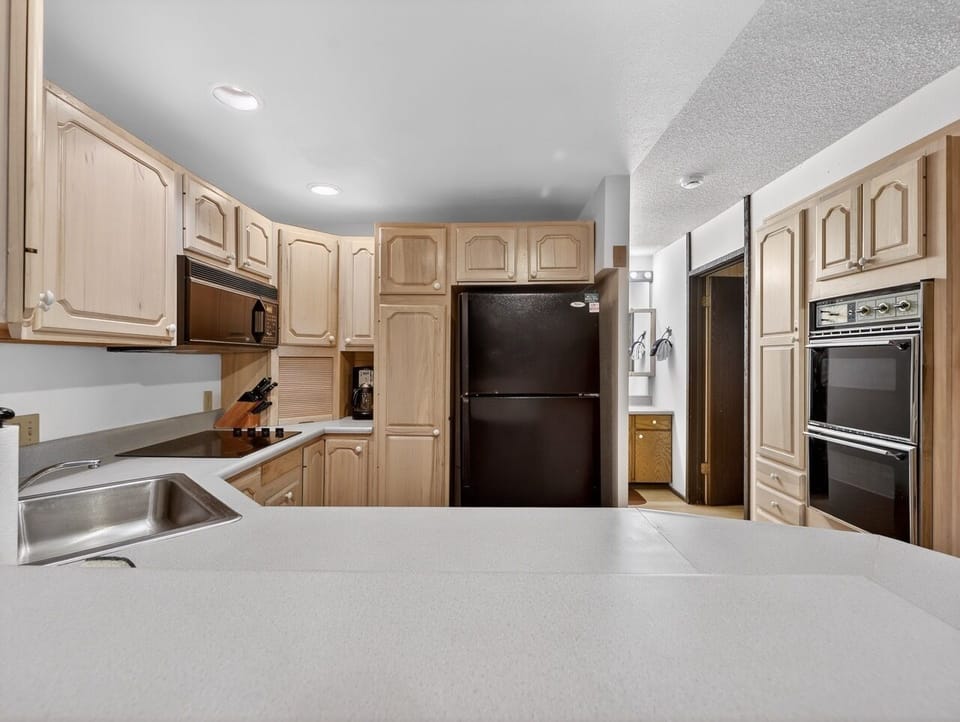Your spacious kitchen awaits with warm wood cabinets, modern appliances, and plenty of counter space for preparing memorable meals during your stay.