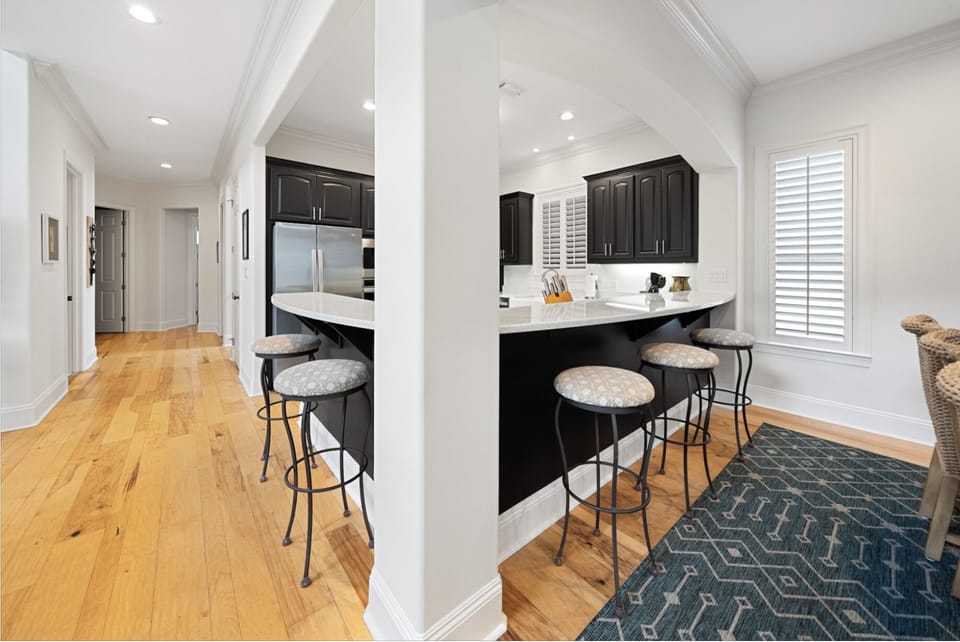 Your gourmet kitchen features sleek black cabinetry, marble countertops, and a spacious island perfect for morning coffee or casual dining.