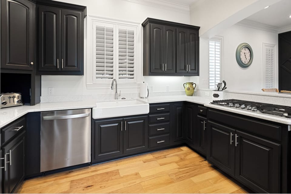 Your fully equipped kitchen features sleek dark cabinetry, marble countertops, and modern appliances - perfect for preparing memorable meals during your stay.