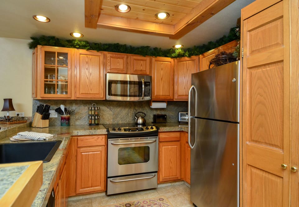 Updated kitchen with elegant lighting, granite countertops & high-end cabinets.