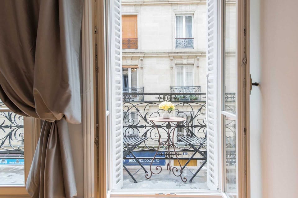 Two sets of French doors open to the apartment's balcony.