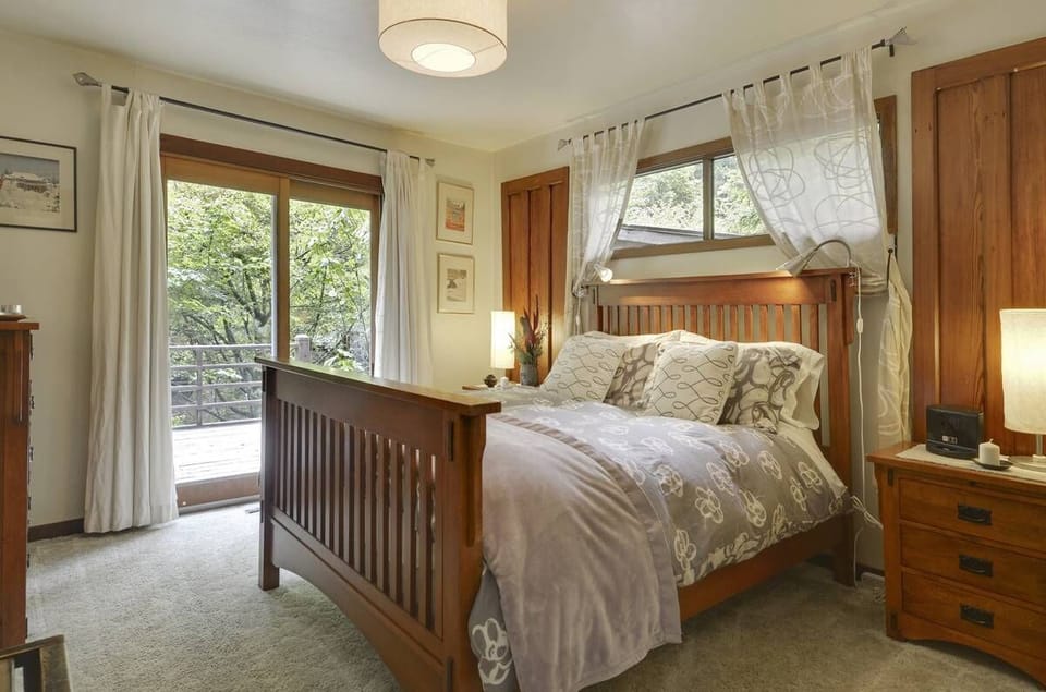Light, airy bedroom, deck access, and water views. 