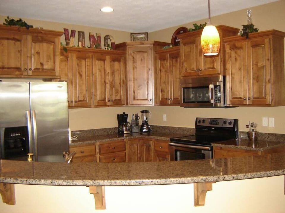 Large kitchen with granite counters and stainless steel appliances.