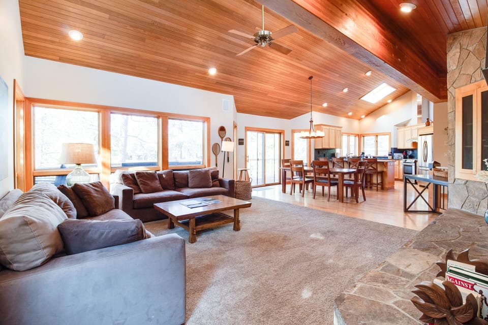 Main living area with high vaulted ceilings, big sunny windows, gas fireplace.