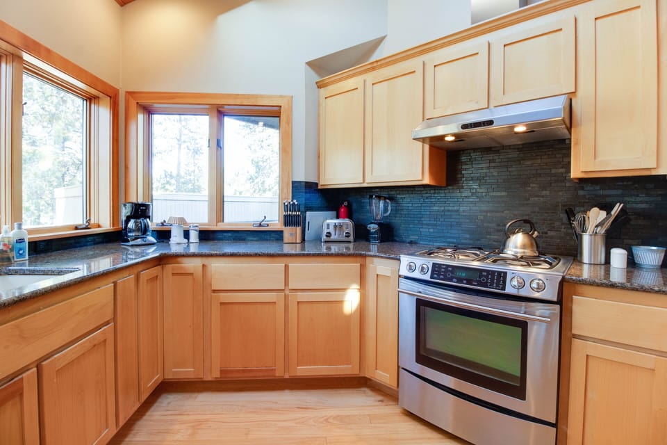 Gourmet kitchen with views to Woodland hole 12, deck and hot tub.